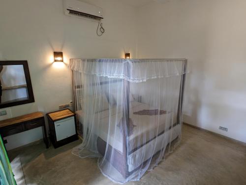 a room with a bed with a curtain on it at Beach View in Arugam Bay