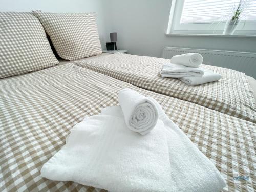 a bedroom with two beds with towels on them at Ferienhaus Lindenweg Bad Bederkesa in Bad Bederkesa