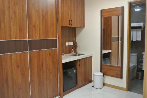 a bathroom with wooden cabinets and a sink at Sunset House Roxas Bay in Manila