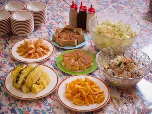 a table topped with plates of food and bowls of food at Hotel Miyuki Beach in Onna