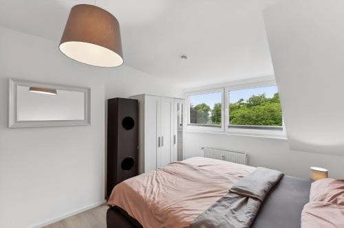 a white bedroom with a bed and two windows at Aarper Boutique Apartment I Messe, Airport, Netflix & Forest in Düsseldorf