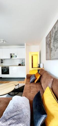 - un salon avec un canapé brun et des oreillers jaunes dans l'établissement New & serene 1-bedroom apart near #LaDéfenseParis #Parking&Fibre, à Suresnes