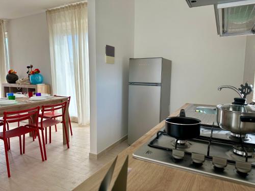 a kitchen with a stove and a table with chairs at Attico al Sovrano - Nel cuore della Puglia! in Turi