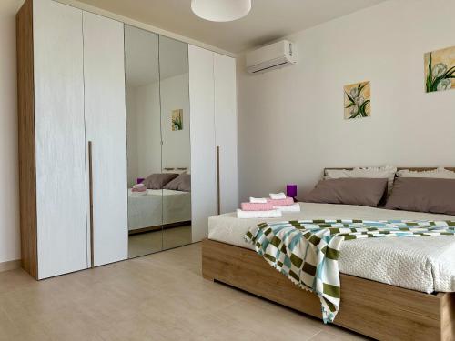 a bedroom with a bed and a mirrored cabinet at Attico al Sovrano - Nel cuore della Puglia! in Turi