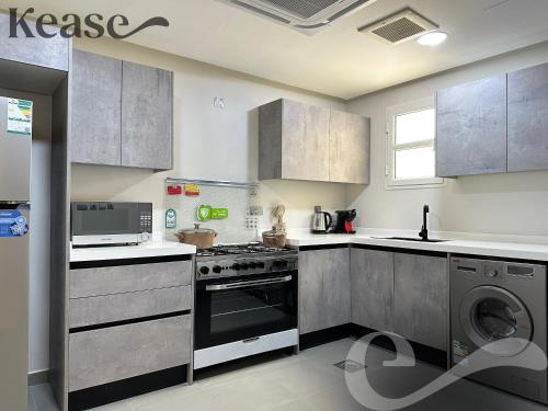 a kitchen with a stove and a washing machine at Kease Qurtubah A-9 Royal Design AG97 in Riyadh