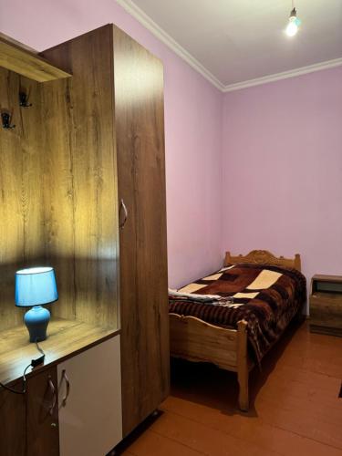 a bedroom with a bed and a large wooden cabinet at Vodo's Guesthouse in Chvabiani
