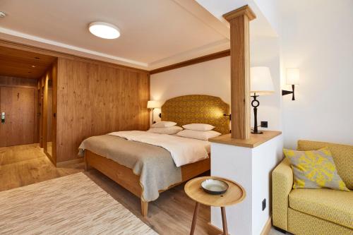 a bedroom with a large bed and a couch at Hotel Hochschober in Turracher Hohe