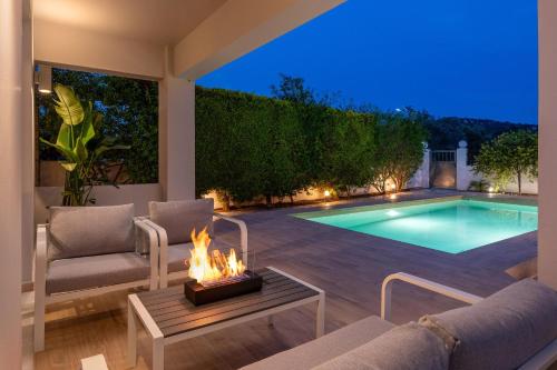 Un patio trasero con piscina y fogata. en Niovis Villa, en Pastida