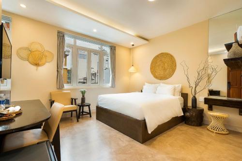 a hotel room with a bed and a desk and a table at HemTouch House in Ho Chi Minh City