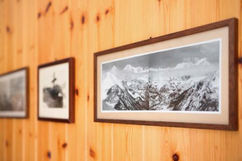 two pictures of mountains are hanging on a wall at Appartamenti Larice Pila in Pila