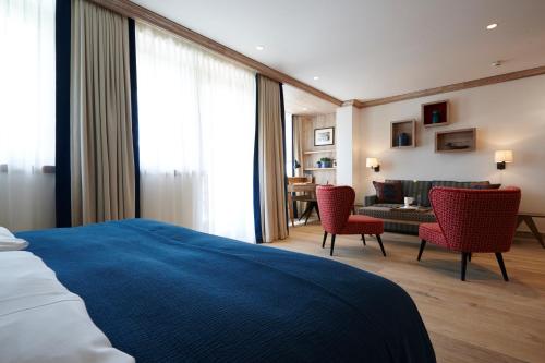 a hotel room with a bed and a living room at Hotel Hochschober in Turracher Hohe