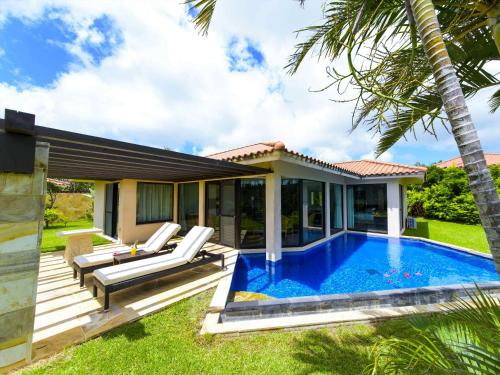 a villa with a swimming pool and a house at Kanehide Kise Country Club in Nago