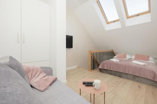 a living room with a couch and a bed at Apartament dwupoziomowy 17 in Rewal