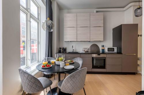 a kitchen with a table and chairs in a kitchen at Perfect City-Break Apartment in CPH in Copenhagen