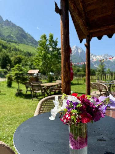 a vase filled with flowers sitting on a table at Guesthouse HYSA in Valbonë