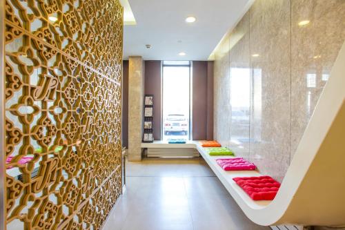 a lobby with a bench with red pillows on it at Jinjiang Inn Datong Pingcheng Bridge in Datong