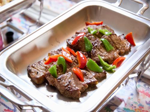 a dish of steak with peppers and onions at Hotel Miyuki Beach in Onna