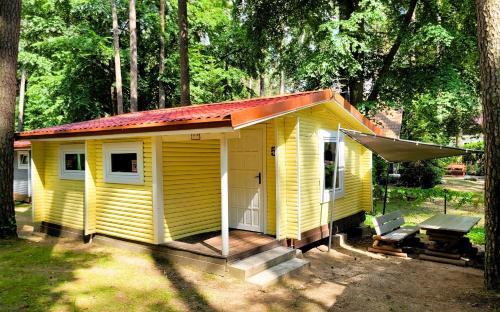 a small yellow house with a red roof at Letnisko BAJKA in Iława