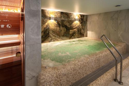 a bathroom with a shower with a bed in it at Palangos Vetra in Palanga