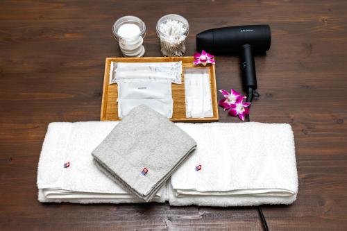 a group of towels and a hair dryer on a table at Anew villa on Tokashiki island, walk to the beach in Awaren
