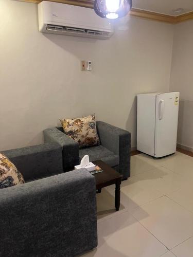 a living room with a couch and a refrigerator at Afaq Al Raha in Khamis Mushayt