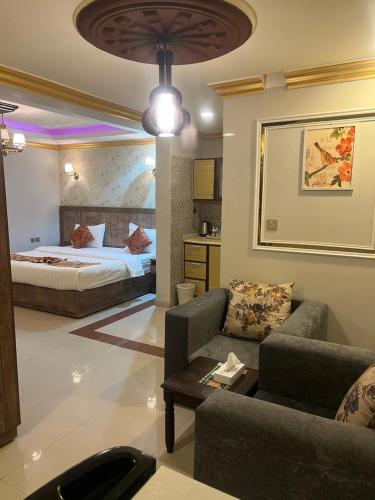 a bedroom with a bed and a living room with a couch at Afaq Al Raha in Khamis Mushayt
