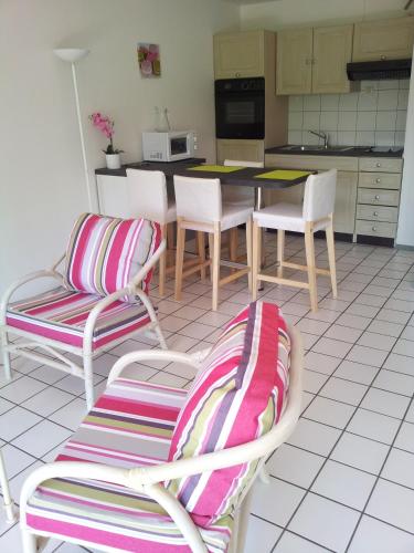 une cuisine avec deux chaises et une table avec dans l'établissement Confortable Studio en Bord de Mer, à Anglet