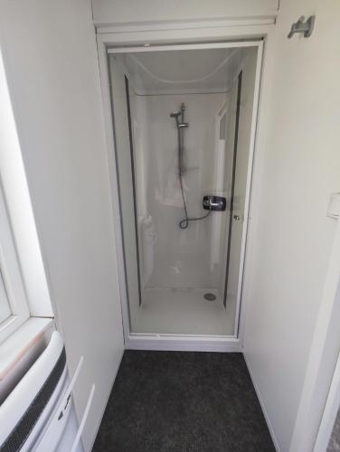 La salle de bains blanche est pourvue d'une douche à l'italienne. dans l'établissement Camping Roc de l'Arche, à Espalion