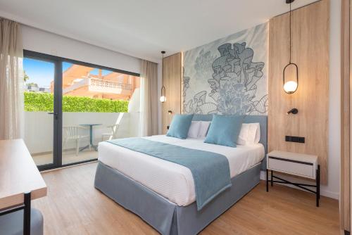 a bedroom with a bed and a large window at Hotel Palia Tropico Playa in Palmanova