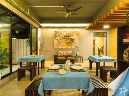 comedor con 2 mesas y ventilador de techo en Sea Front Home Hotel - Patong Beach, en Patong Beach