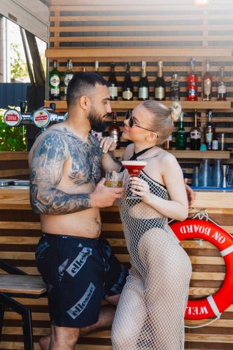 a man and a woman standing next to a bar at Biruza Club in Svyatopetrivske