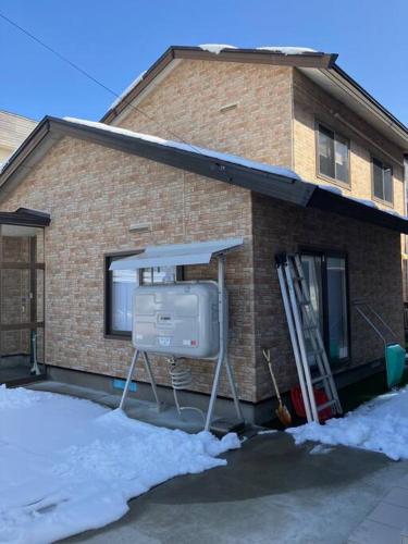 a house with a television in front of it at Taro's House Midori in Aomori