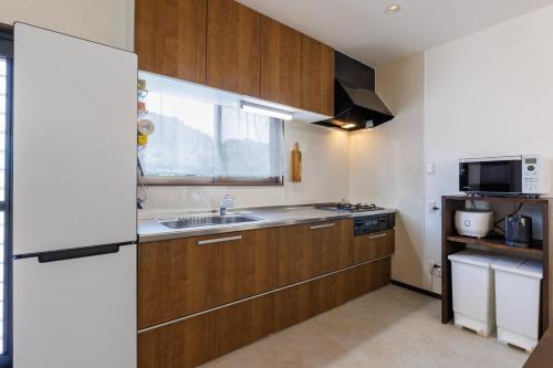 a kitchen with wooden cabinets and a sink and a window at Kerama the day in Awaren