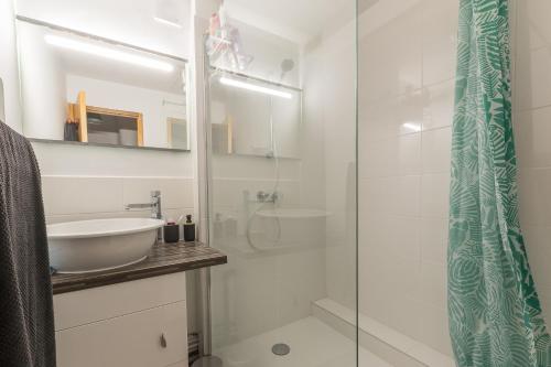 a bathroom with a sink and a glass shower at L'Endroit - au pied de la station in Saint-Léger-les-Mélèzes