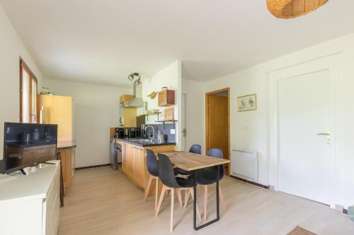 une cuisine et une salle à manger avec une table et des chaises dans l'établissement L'Endroit - au pied de la station, à Saint-Léger-les-Mélèzes