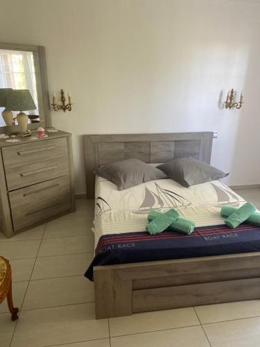 une chambre avec un grand lit et une commode dans l'établissement La Galiote, à Agde