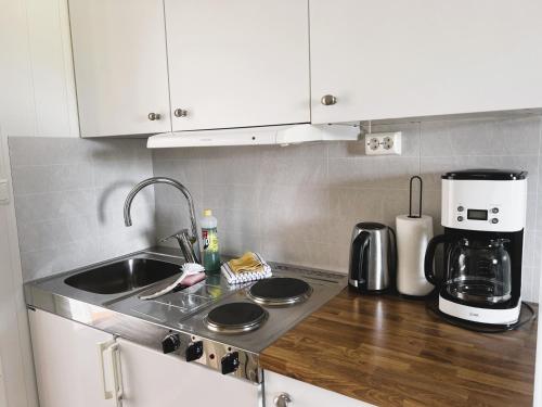 a kitchen counter with a sink and a coffee maker at Lofoten Rorbuer in Svolvær