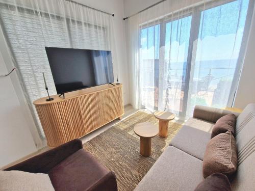 a living room with a couch and a flat screen tv at Cabacum Paradise 1 on the seashore in Varna City
