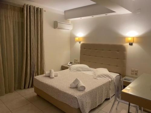 a bedroom with a bed with towels on it at Ammos Suites in Platy