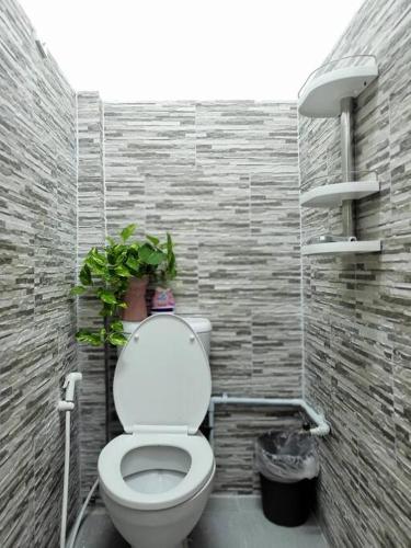 a bathroom with a toilet with a plant on it at auntythong house in Bangkok