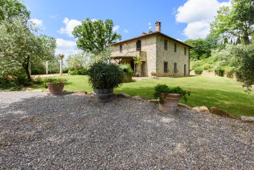 an old stone house with potted plants in front of it at Villa Tregole by Mmega in Fonterutoli