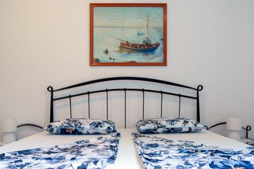 a bedroom with two beds and a painting of a boat at VIlla Ribar in Podgora