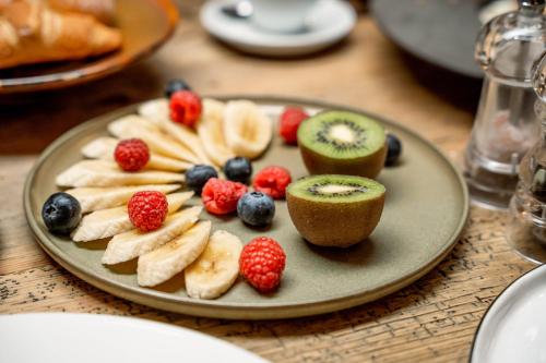a plate of fruit on a wooden table at Hotel Rigele Royal Superior in Obertauern