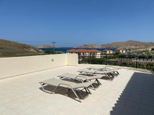 a row of lounge chairs sitting on a patio at Ammos Suites in Plati