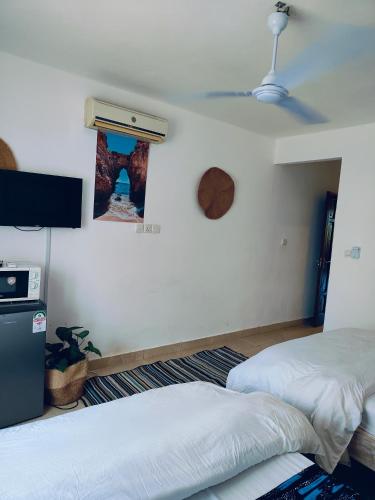 a bedroom with two beds and a wall with a window at Beach Front Luxury 2 Bedroom Mombasa in Mombasa