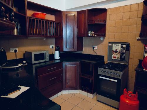 a kitchen with wooden cabinets and a stove top oven at Beach Front Luxury 2 Bedroom Mombasa in Mombasa
