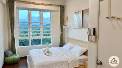 une chambre avec un lit blanc avec une fenêtre dans l'établissement Trival Blessing Cottage Homestay Sri Indah Sandakan, à Sandakan