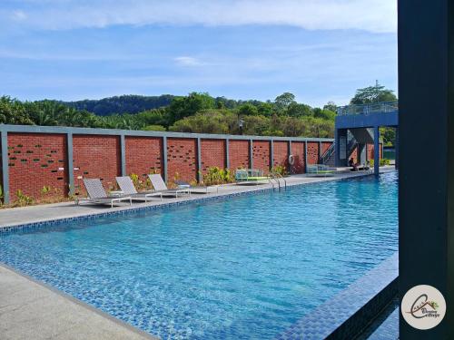 une piscine avec des chaises sur un bâtiment dans l'établissement Trival Blessing Cottage Homestay Sri Indah Sandakan, à Sandakan