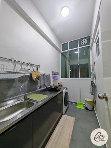 a kitchen with a sink and a washing machine at Trival Blessing Cottage Homestay Sri Indah Sandakan in Sandakan