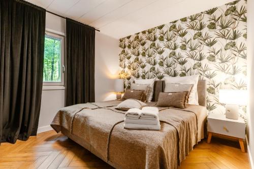 a bedroom with a large bed with a floral wall at Ośrodek Wypoczynkowy Łańsk in Stawiguda